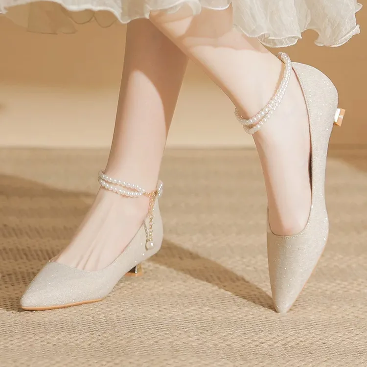 Photo of a bride's short-heeled, pointed-toe shoe, trendy of the year Photo of a bride's shoe with a short heel and pointed toe, trendy this year