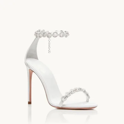White bridal high-heeled sandals with embellishments are trendy.